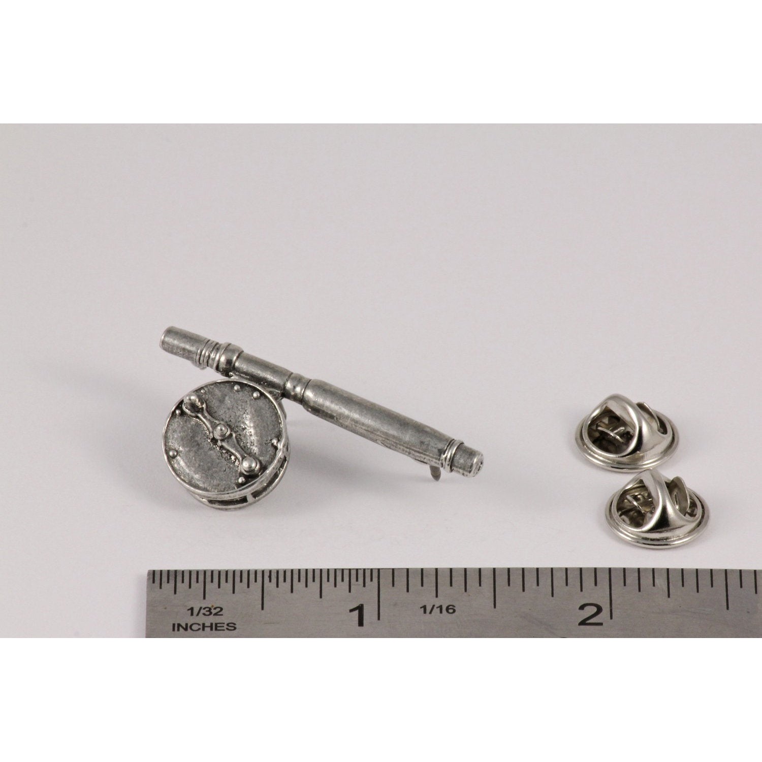 A handcrafted Freshwater Fly Rod Reel Pin next to a ruler, available for sale at Creativeartisan.com - the image offers a sense of scale