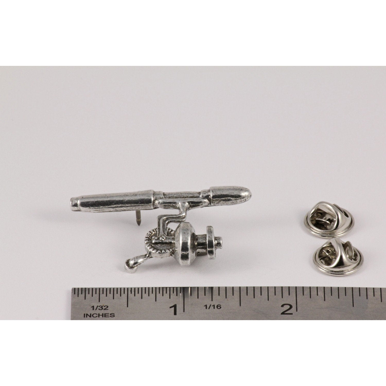 A handcrafted Spinning Rod Reel Pin next to a ruler, available for sale at Creativeartisan.com - the image offers a sense of scale