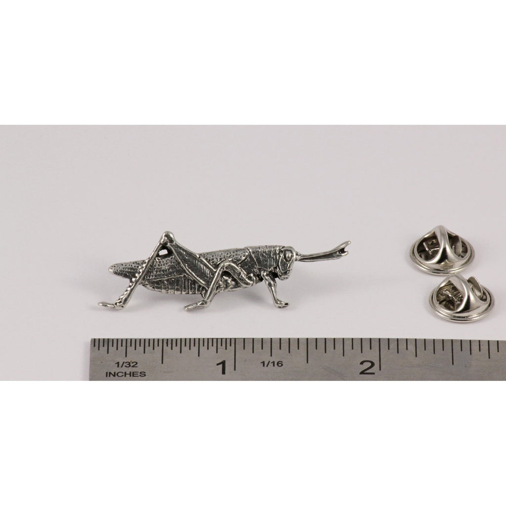 A handcrafted Grasshopper Pin next to a ruler, available for sale at Creativeartisan.com - the image offers a sense of scale