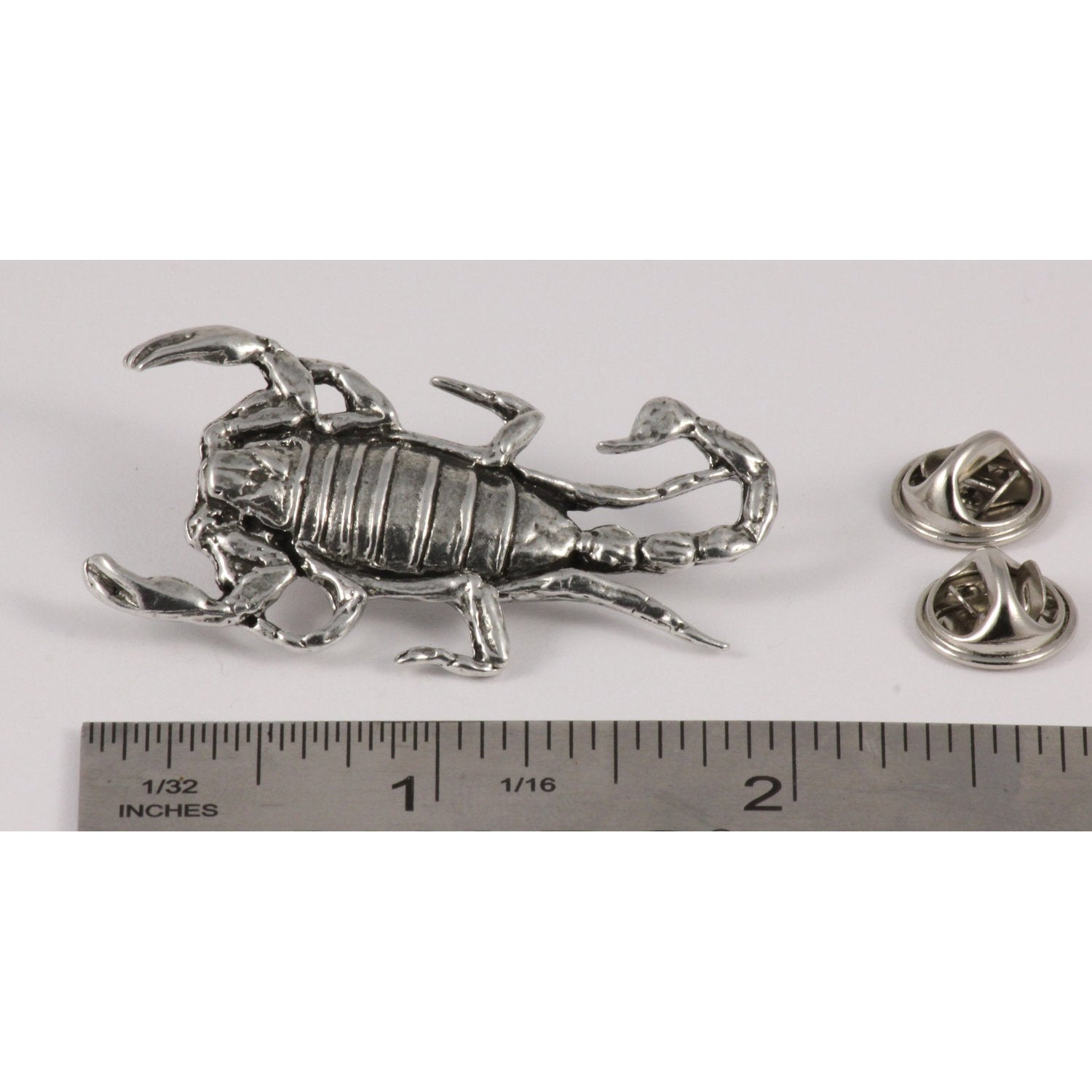 A handcrafted Scorpion Pin next to a ruler, available for sale at Creativeartisan.com - the image offers a sense of scale