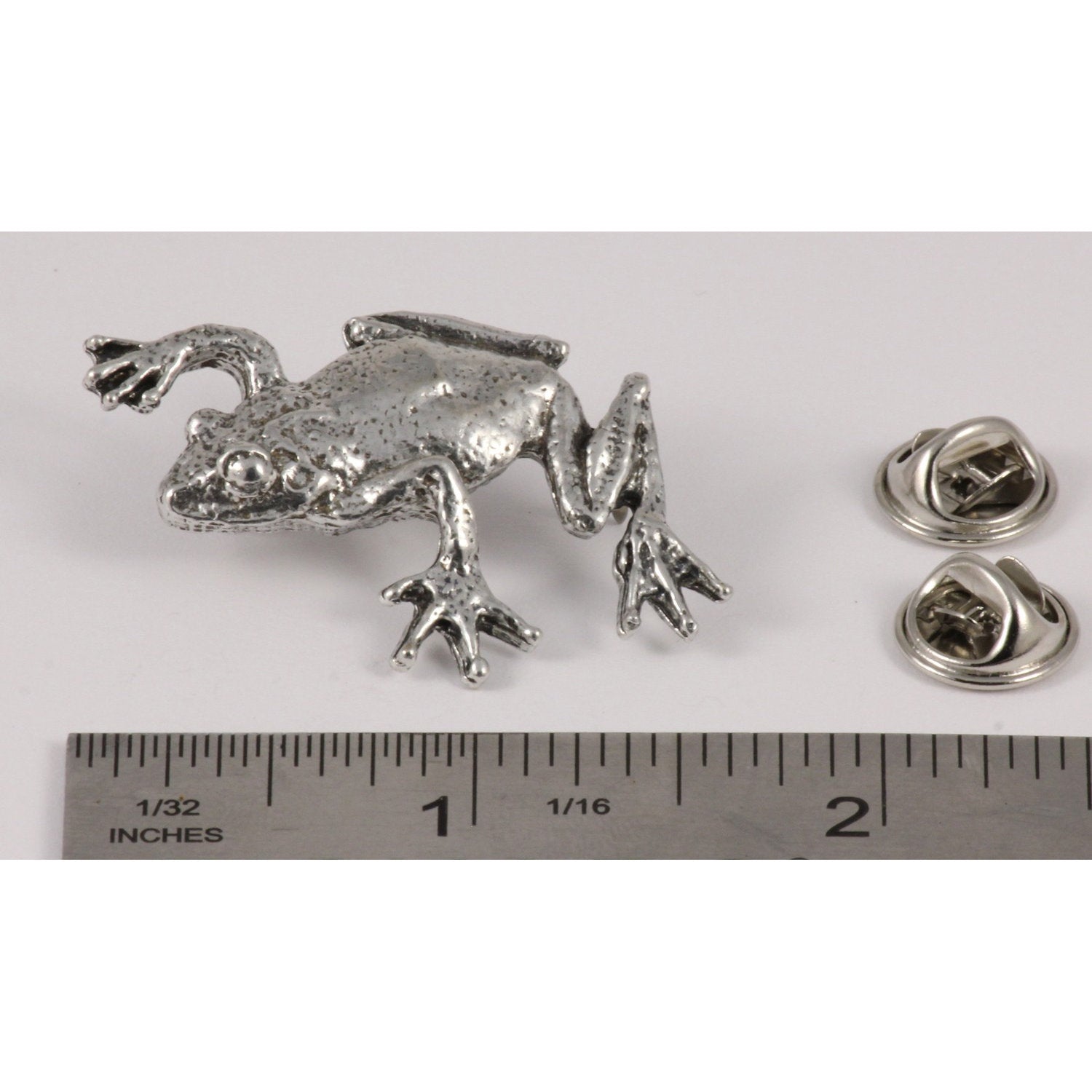 A handcrafted Tree Frog Climbing Pin next to a ruler, available for sale at Creativeartisan.com - the image offers a sense of scale