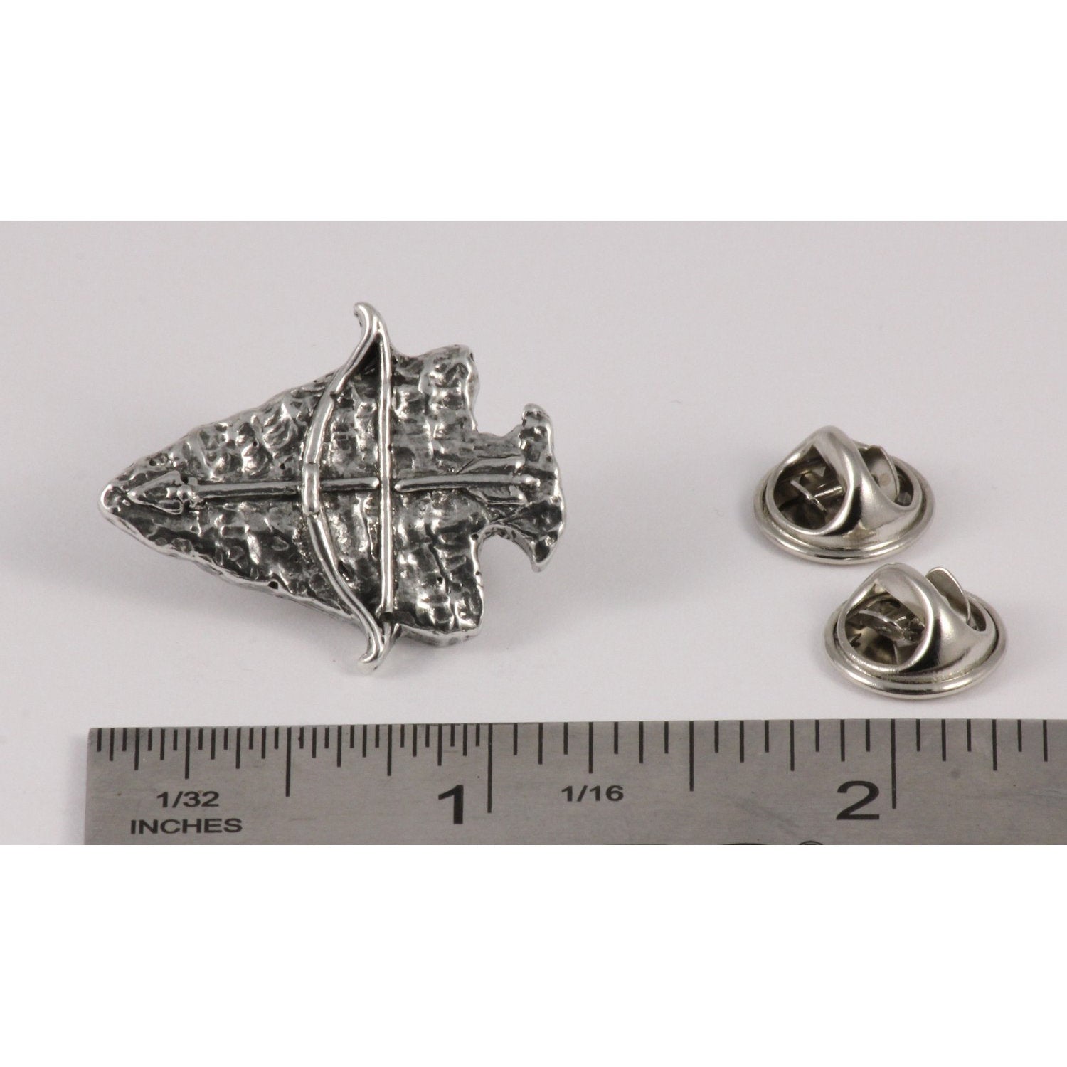 A handcrafted Arrowhead With Bow Pin next to a ruler, available for sale at Creativeartisan.com - the image offers a sense of scale