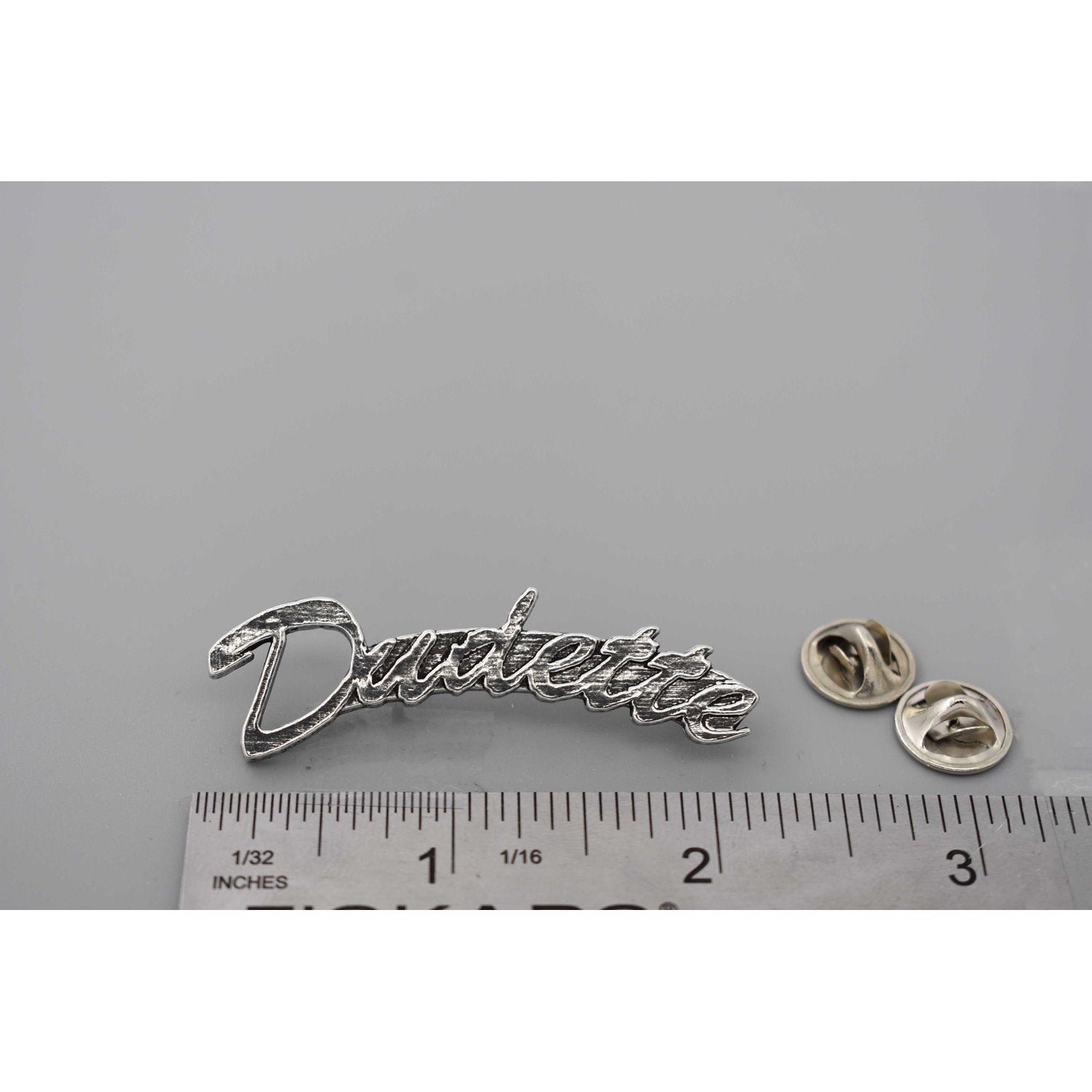 A handcrafted Dudette Pin next to a ruler, available for sale at Creativeartisan.com - the image offers a sense of scale