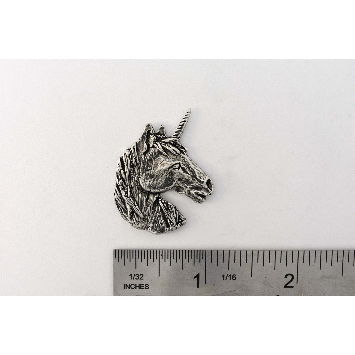 A handcrafted Unicorn Head Pin next to a ruler, available for sale at Creativeartisan.com - the image offers a sense of scale