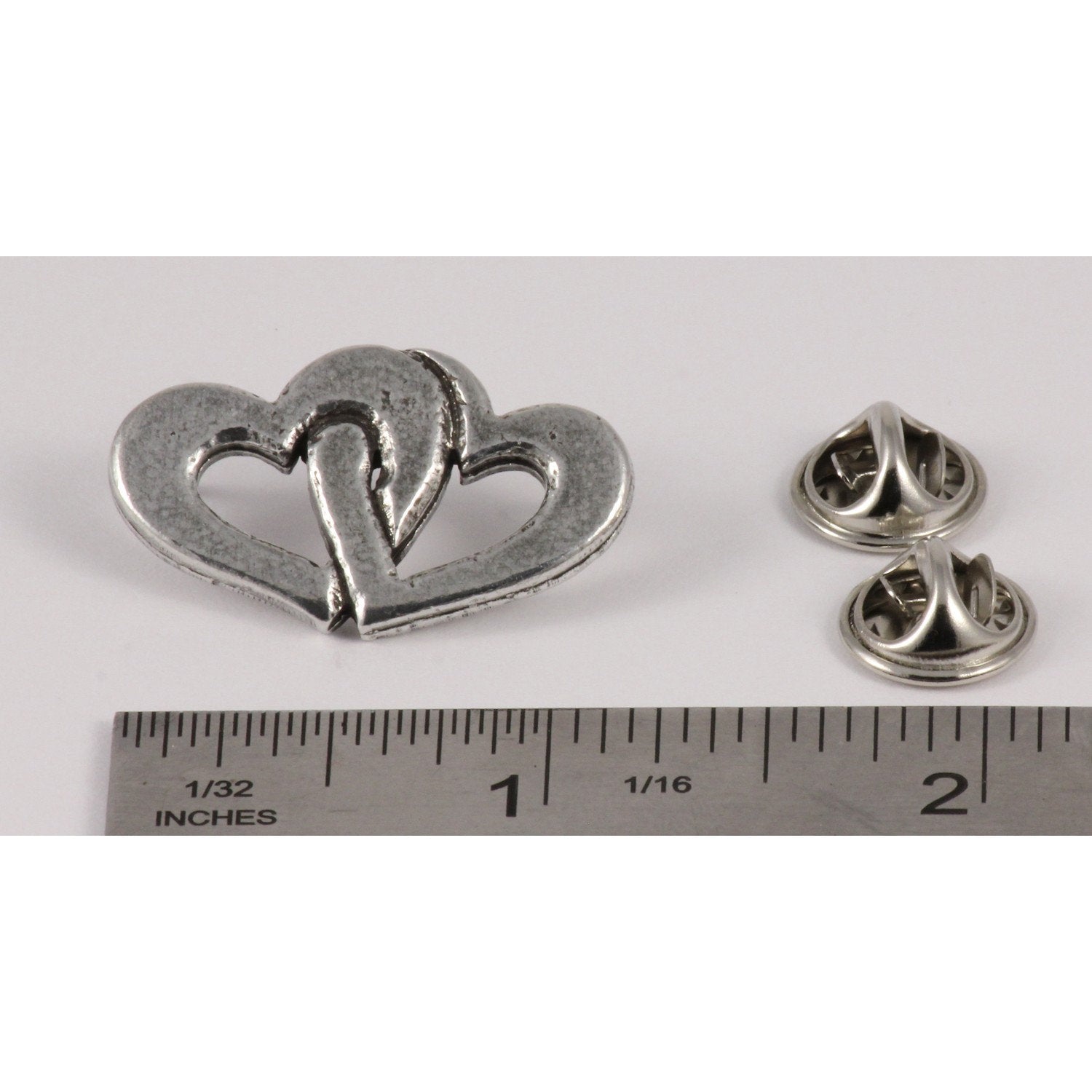 A handcrafted Double Heart Pin next to a ruler, available for sale at Creativeartisan.com - the image offers a sense of scale
