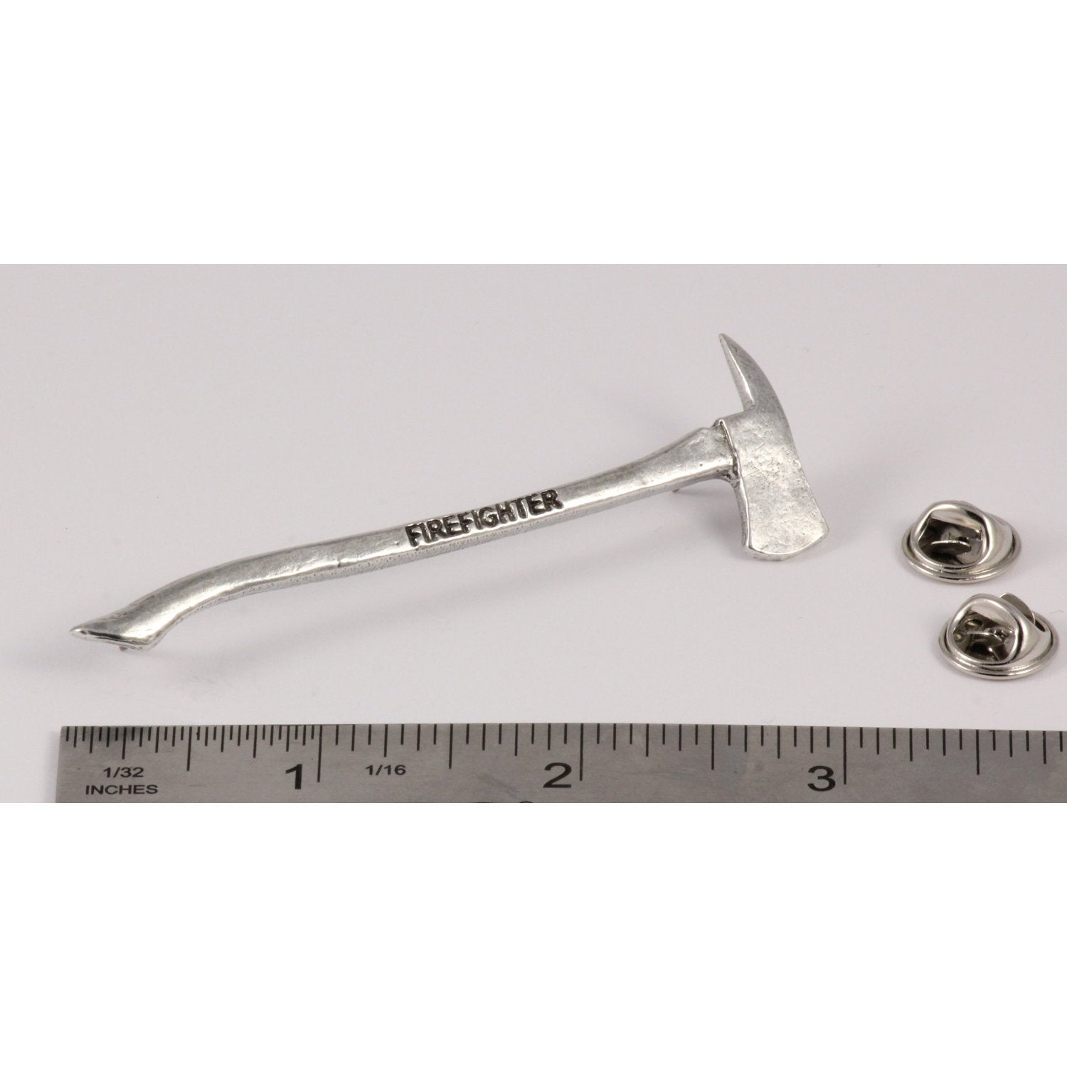 A handcrafted Firemans Axe Firefighter Engraved Pin next to a ruler, available for sale at Creativeartisan.com - the image offers a sense of scale