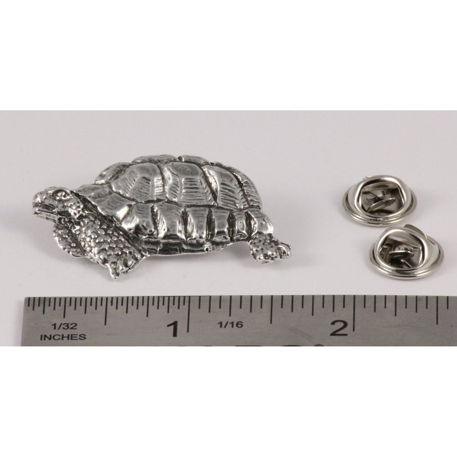 A handcrafted Tortoise Pin next to a ruler, available for sale at Creativeartisan.com - the image offers a sense of scale
