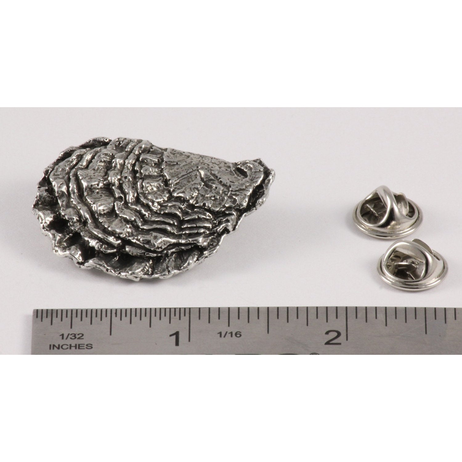 A handcrafted Oyster Shell Pin next to a ruler, available for sale at Creativeartisan.com - the image offers a sense of scale