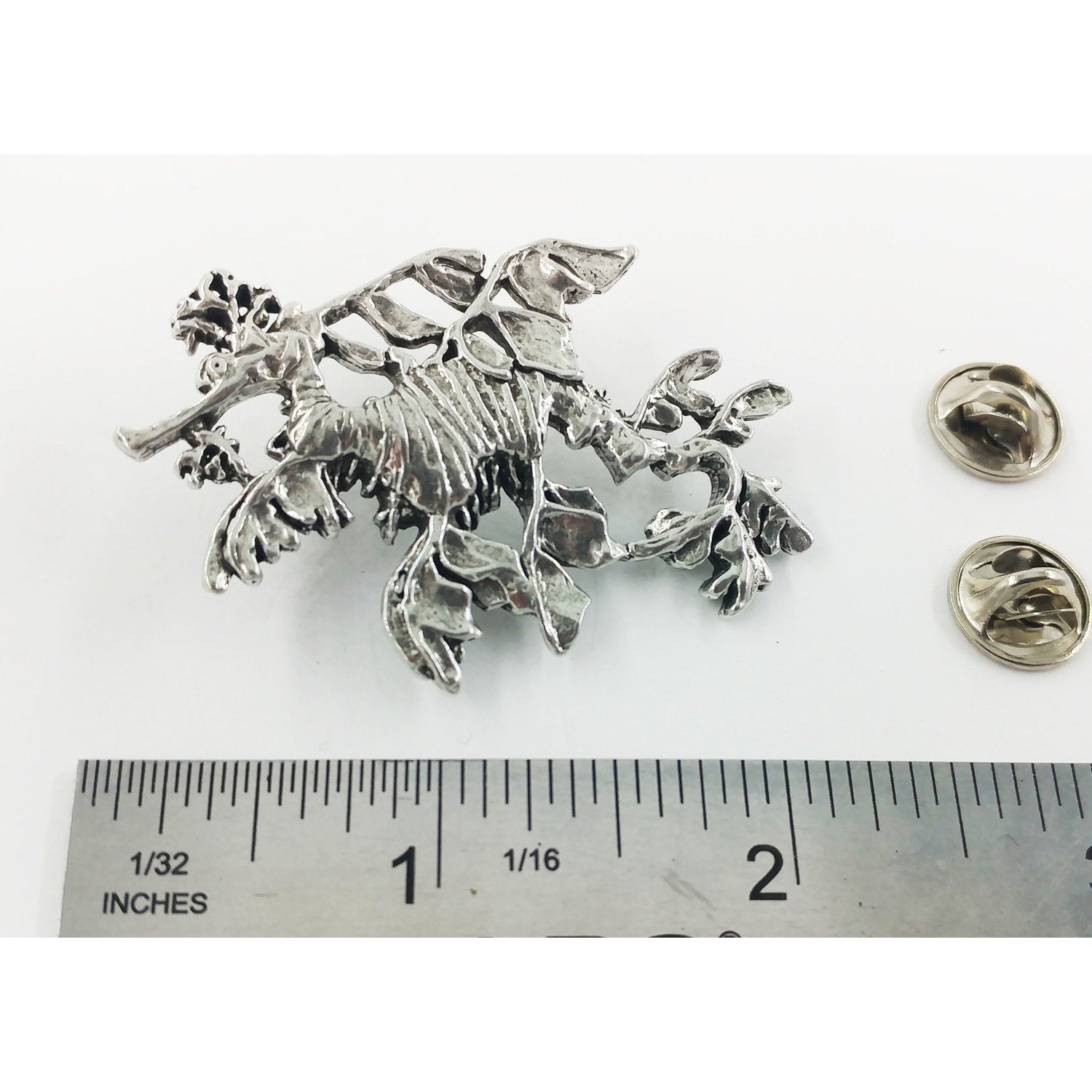 A handcrafted Sea Dragon Leafy Pin next to a ruler, available for sale at Creativeartisan.com - the image offers a sense of scale