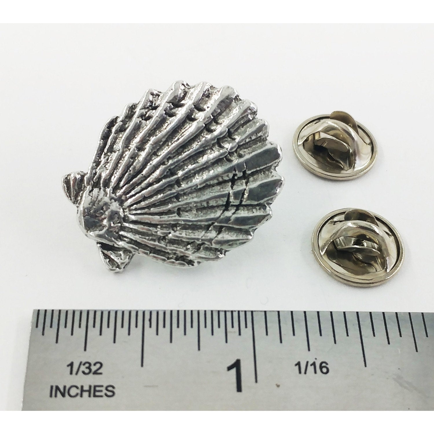 A handcrafted Scallop Shell Pin next to a ruler, available for sale at Creativeartisan.com - the image offers a sense of scale