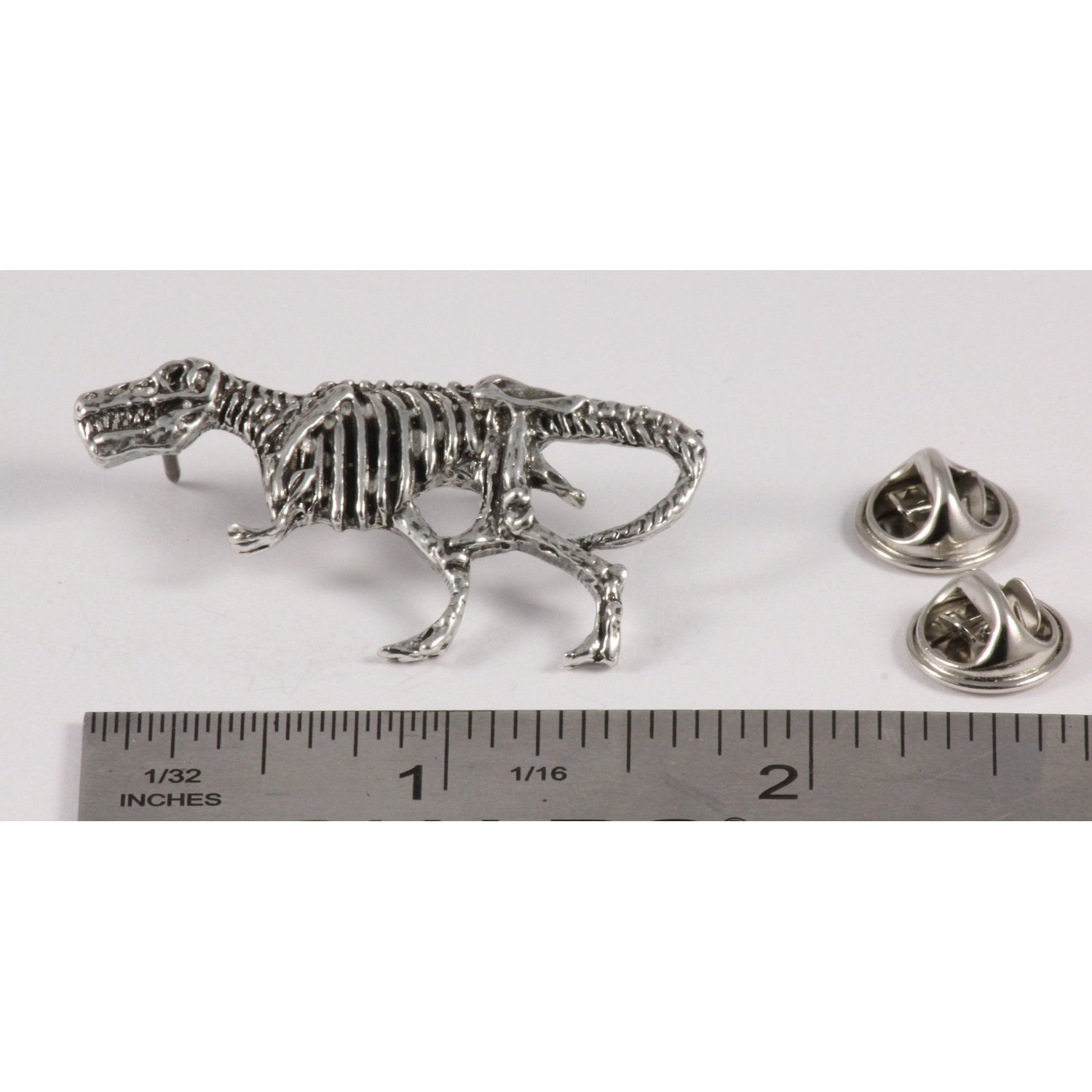 A handcrafted Tyrannosaurus Rex Fossilized Body Pin next to a ruler, available for sale at Creativeartisan.com - the image offers a sense of scale