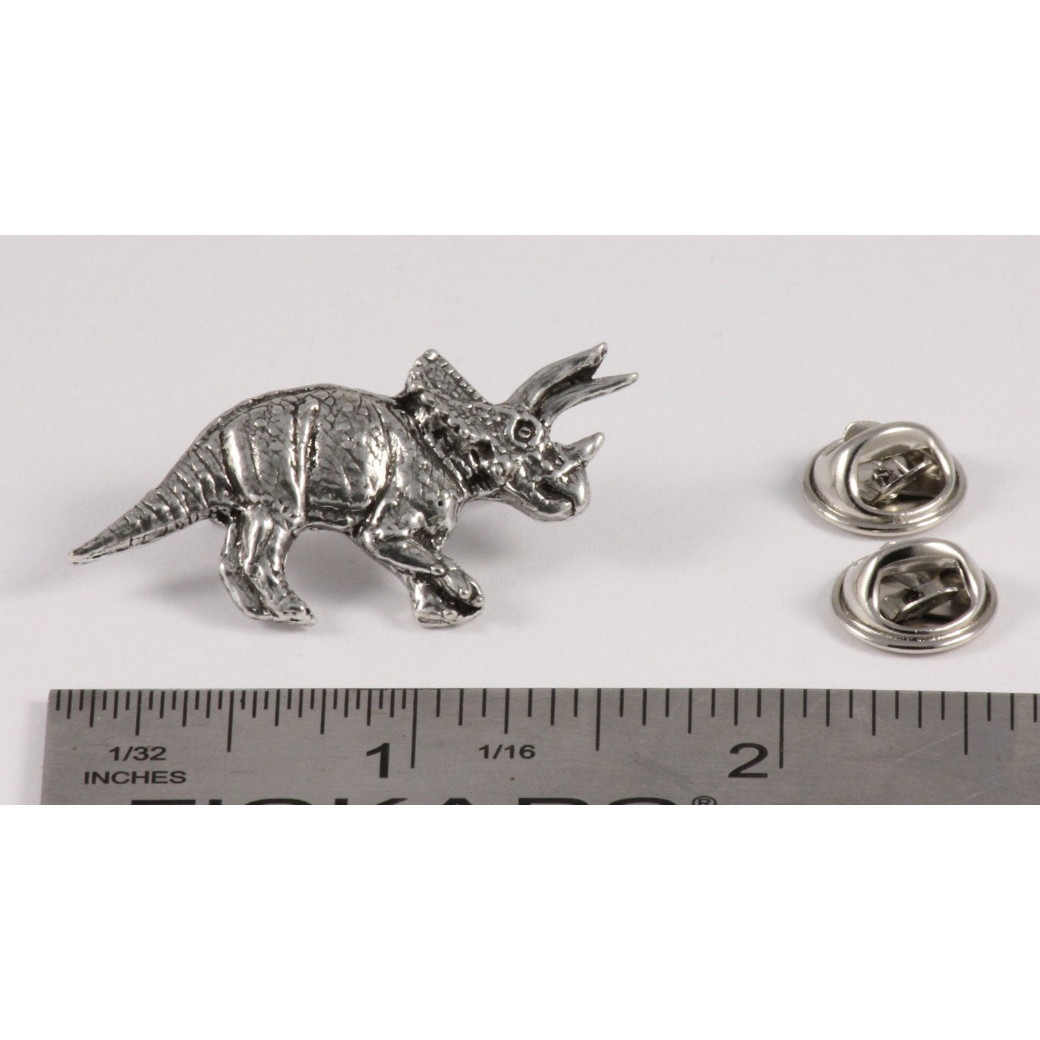 A handcrafted Triceratops Pin next to a ruler, available for sale at Creativeartisan.com - the image offers a sense of scale