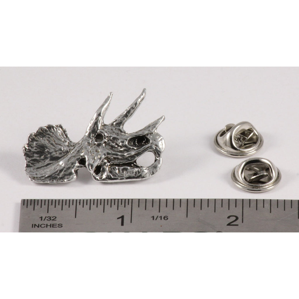 A handcrafted Triceratops Fossilized Head Pin next to a ruler, available for sale at Creativeartisan.com - the image offers a sense of scale