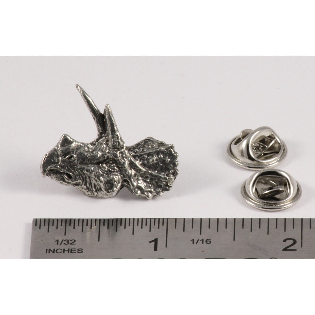 A handcrafted Triceratops Head Pin next to a ruler, available for sale at Creativeartisan.com - the image offers a sense of scale