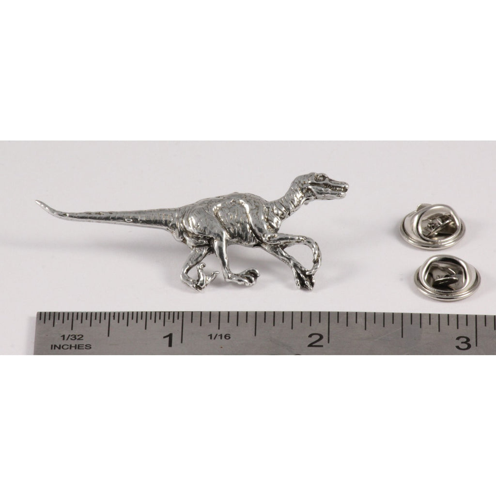 A handcrafted Velociraptor Pin next to a ruler, available for sale at Creativeartisan.com - the image offers a sense of scale