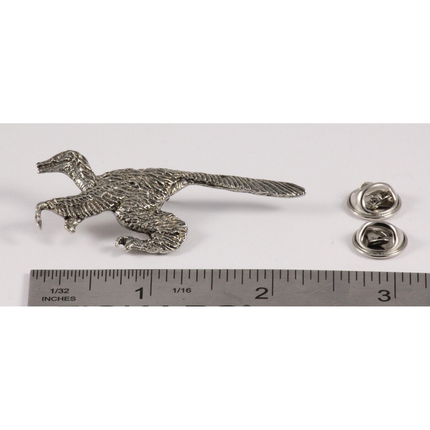 A handcrafted Feathered Velociraptor Pin next to a ruler, available for sale at Creativeartisan.com - the image offers a sense of scale