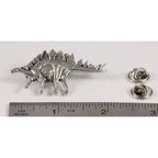 A handcrafted Stegosaurus Pin next to a ruler, available for sale at Creativeartisan.com - the image offers a sense of scale