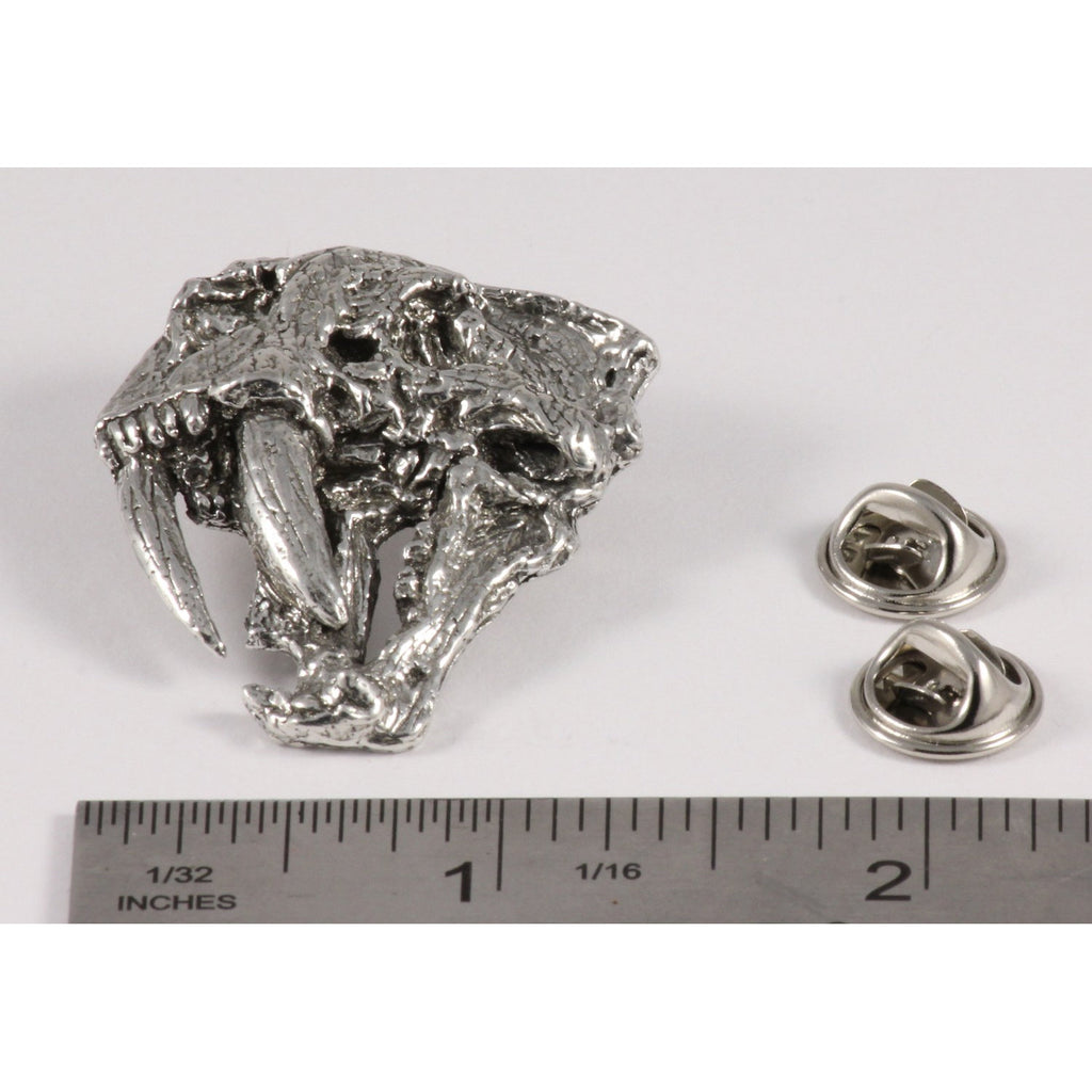 A handcrafted Saber Toothed Cat Skull Pin next to a ruler, available for sale at Creativeartisan.com - the image offers a sense of scale