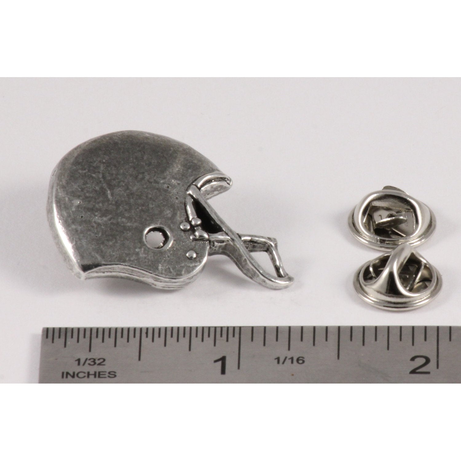 A handcrafted Football Helmet Pin next to a ruler, available for sale at Creativeartisan.com - the image offers a sense of scale