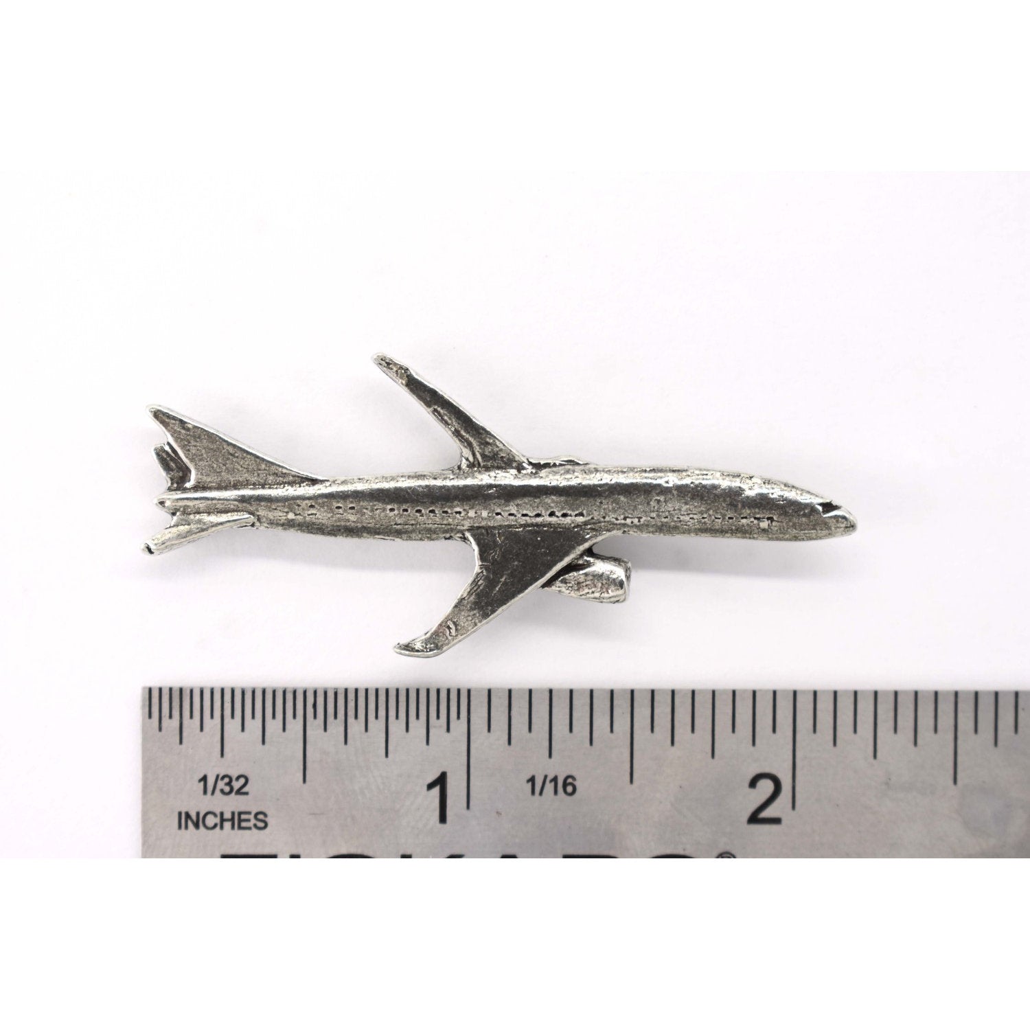 A handcrafted Jetliner Pin next to a ruler, available for sale at Creativeartisan.com - the image offers a sense of scale