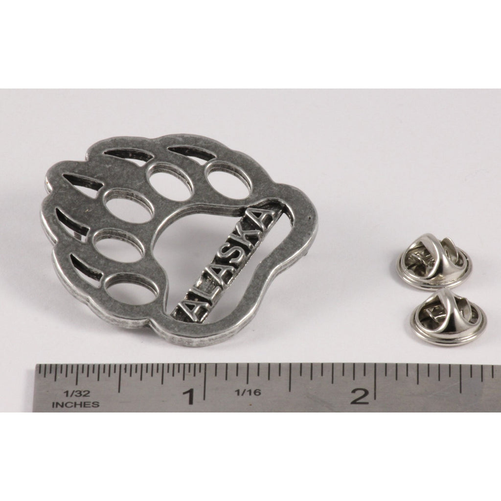 A handcrafted Bear Print Alaska Pin next to a ruler, available for sale at Creativeartisan.com - the image offers a sense of scale