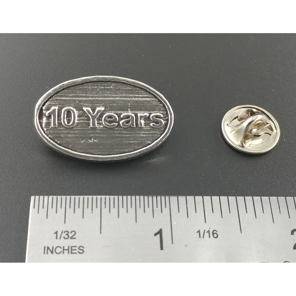 A handcrafted 10 Year Pin next to a ruler, available for sale at Creativeartisan.com - the image offers a sense of scale