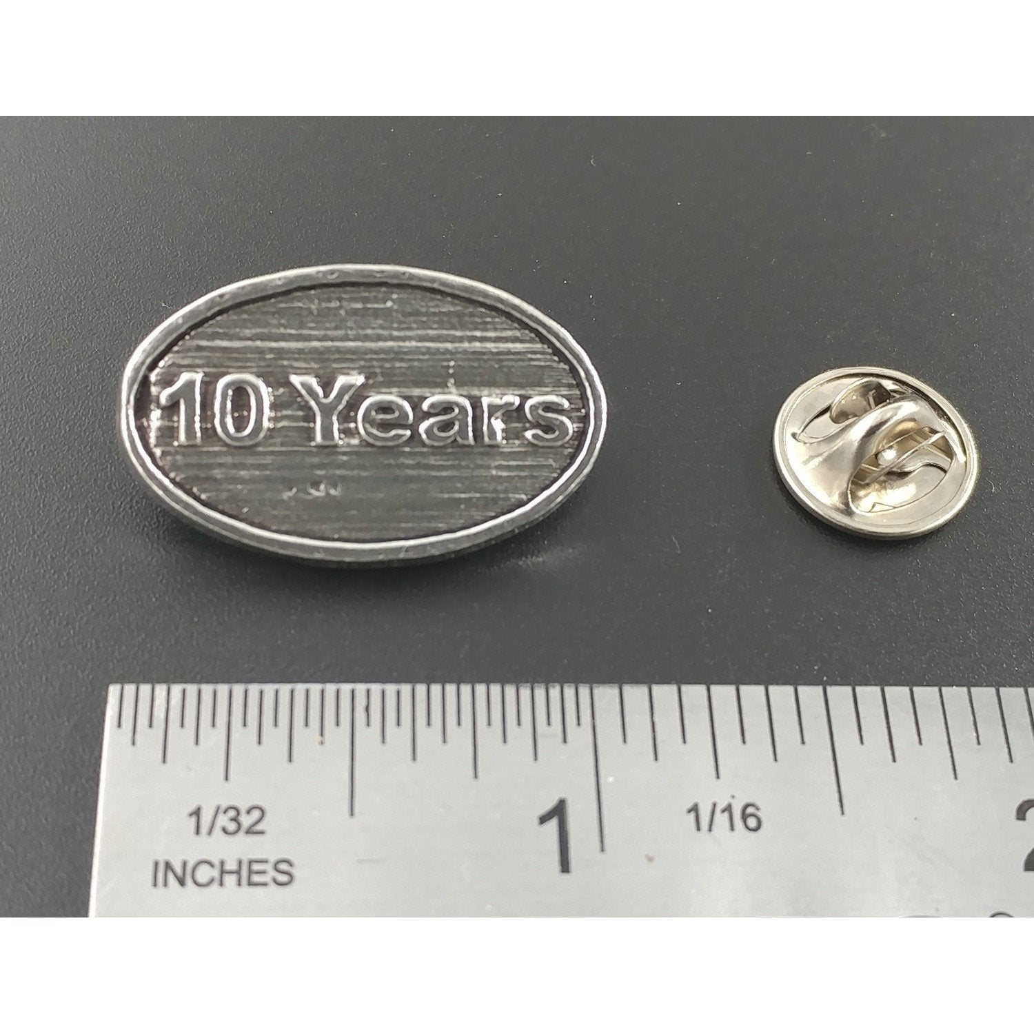 A handcrafted 10 Year Pin next to a ruler, available for sale at Creativeartisan.com - the image offers a sense of scale