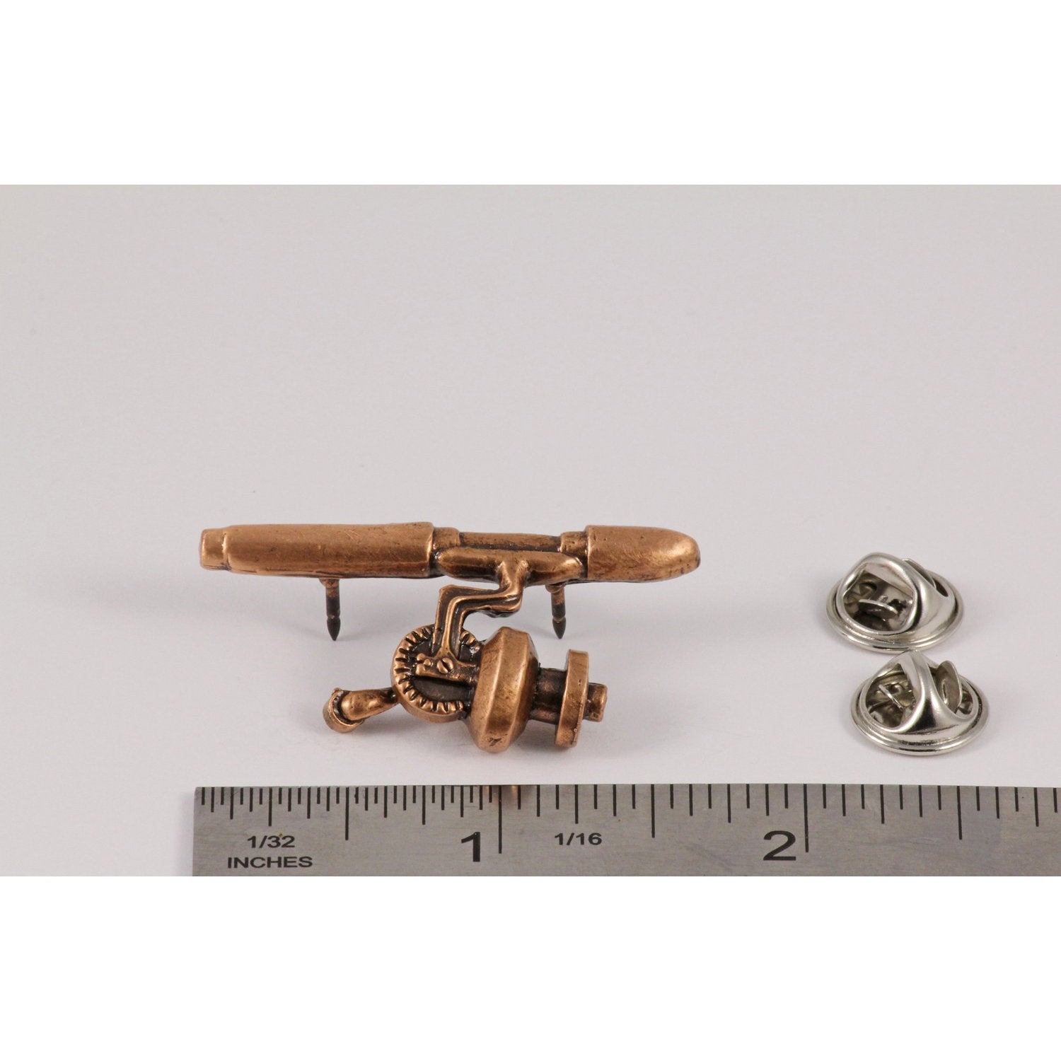 A handcrafted Spinning Rod Reel Pin next to a ruler, available for sale at Creativeartisan.com - the image offers a sense of scale