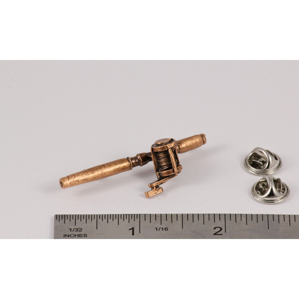 A handcrafted Bait Casting Rod Reel Pin next to a ruler, available for sale at Creativeartisan.com - the image offers a sense of scale