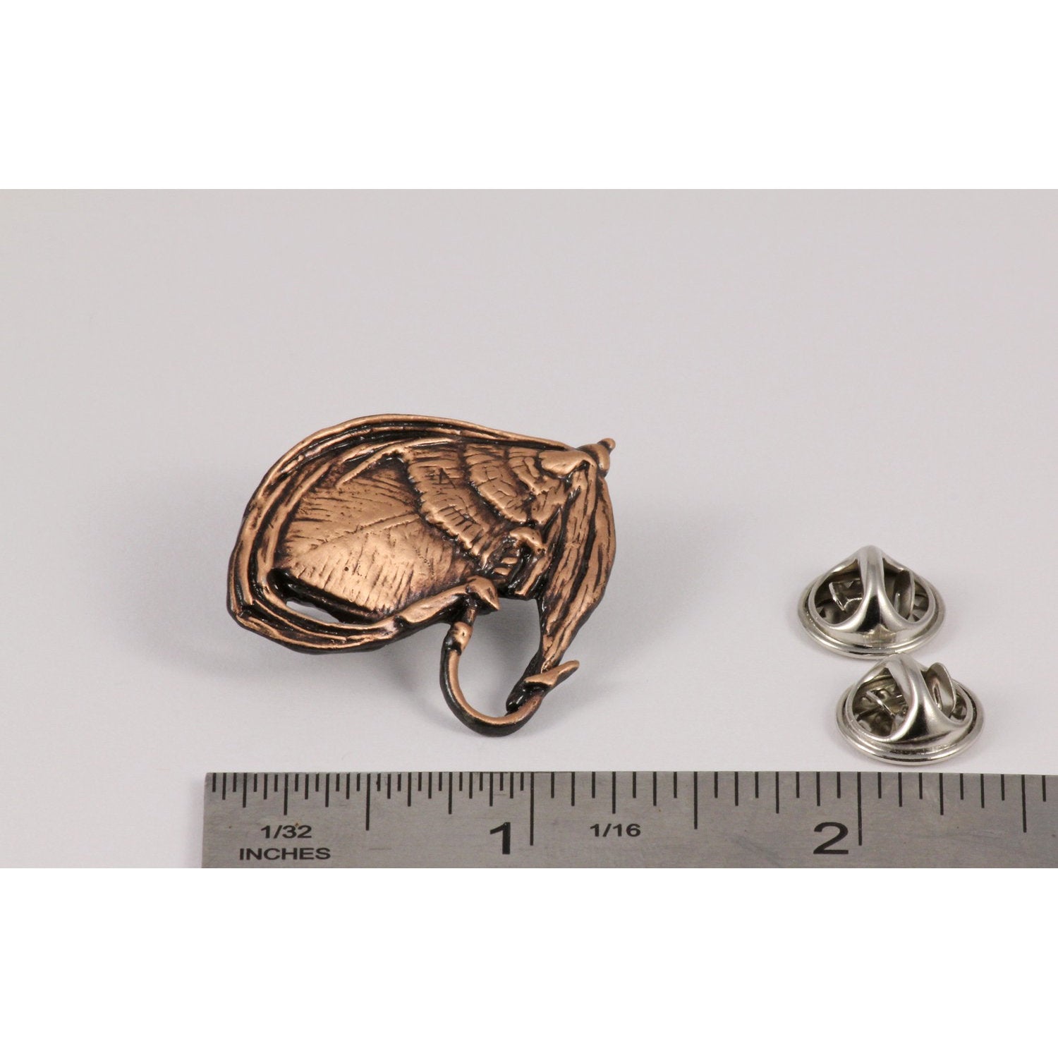 A handcrafted Salmon Fly Pin next to a ruler, available for sale at Creativeartisan.com - the image offers a sense of scale