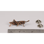 A handcrafted Grasshopper Pin next to a ruler, available for sale at Creativeartisan.com - the image offers a sense of scale