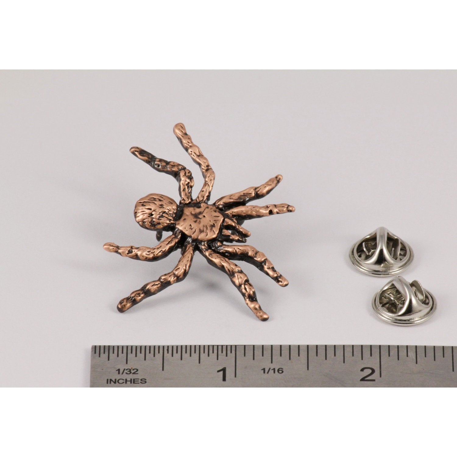 A handcrafted Tarantula Pin next to a ruler, available for sale at Creativeartisan.com - the image offers a sense of scale