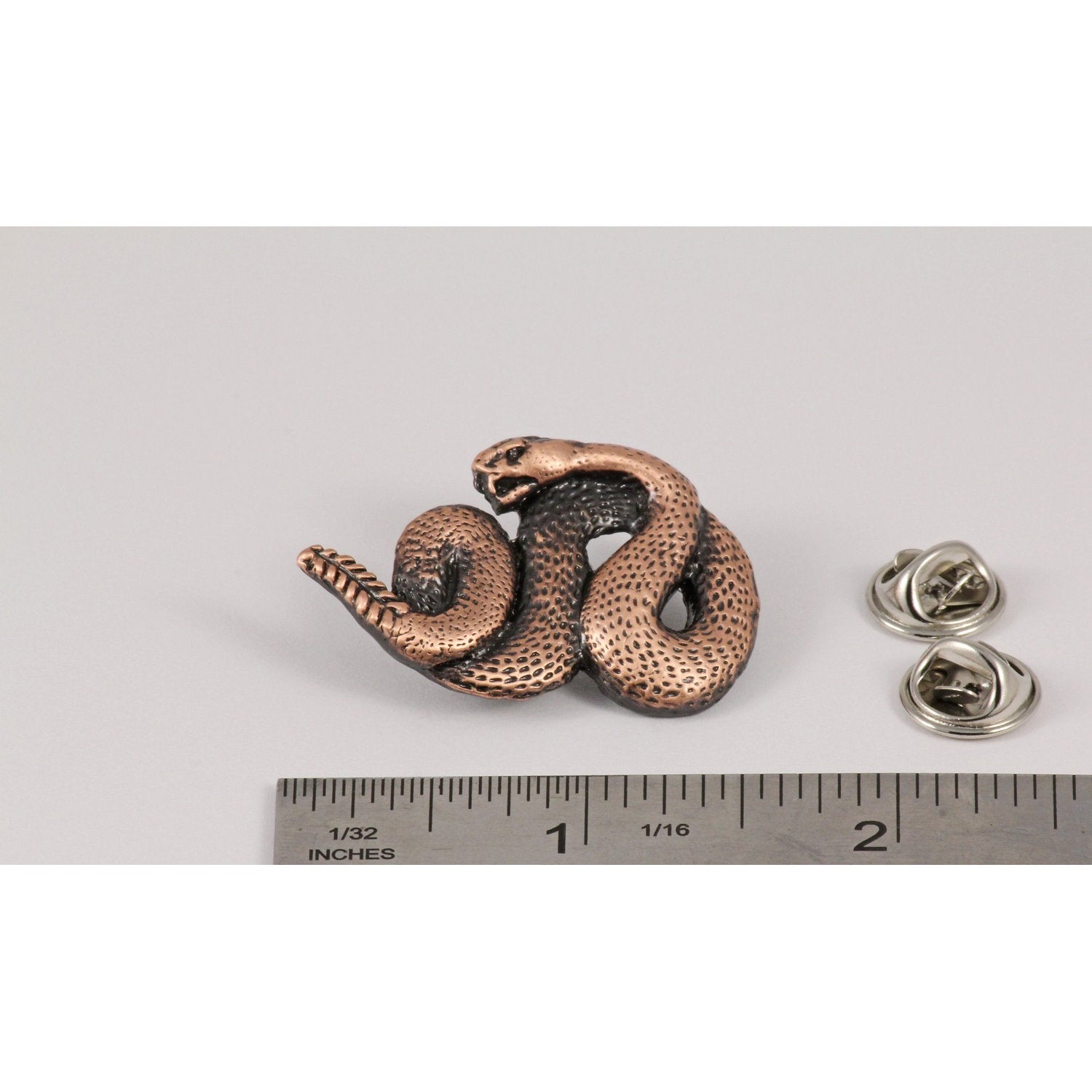 A handcrafted Rattlesnake Pin next to a ruler, available for sale at Creativeartisan.com - the image offers a sense of scale