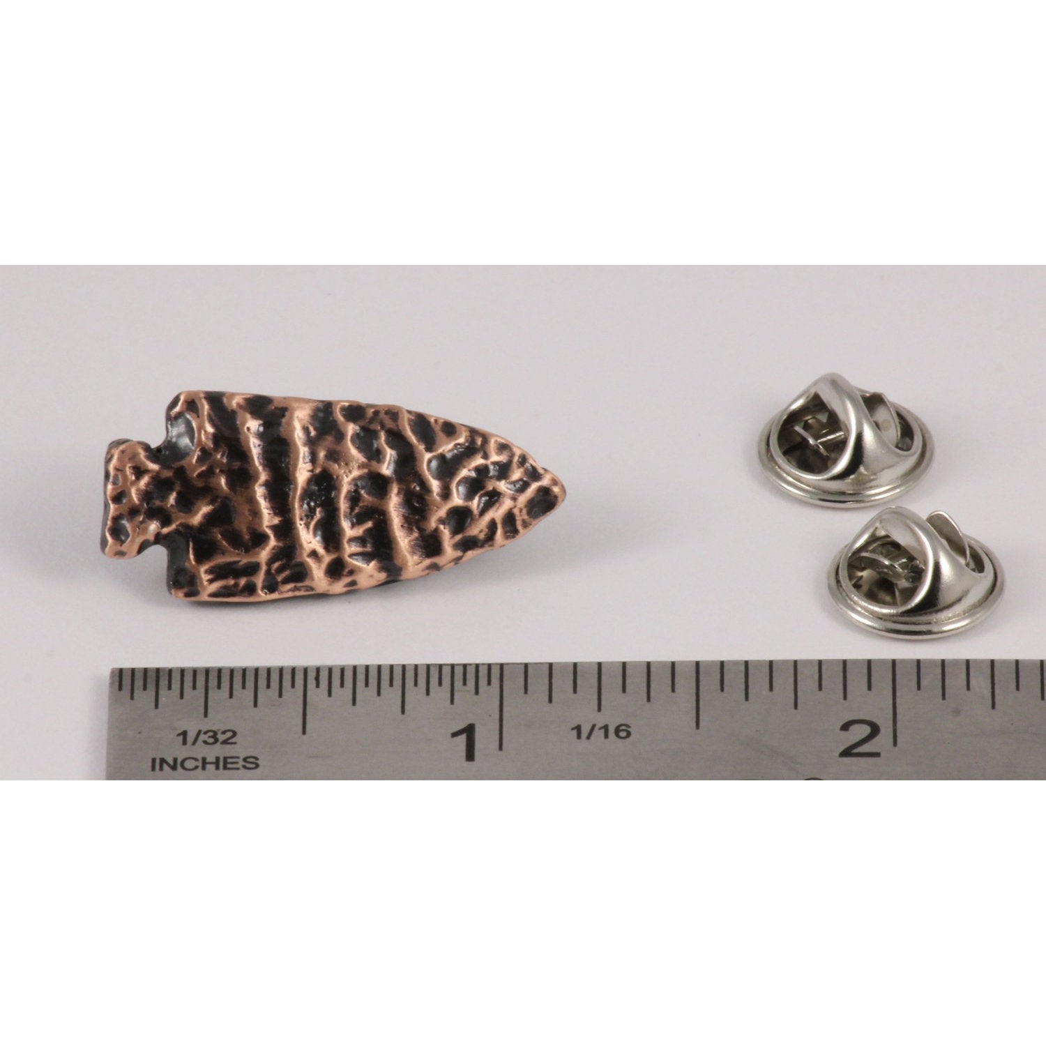 A handcrafted Native American Arrowhead Pin next to a ruler, available for sale at Creativeartisan.com - the image offers a sense of scale