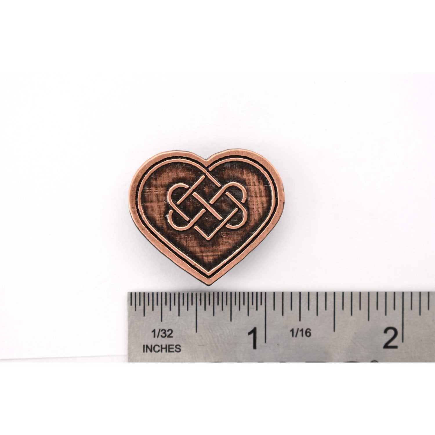 A handcrafted Heart With Celtic Knot Pin next to a ruler, available for sale at Creativeartisan.com - the image offers a sense of scale