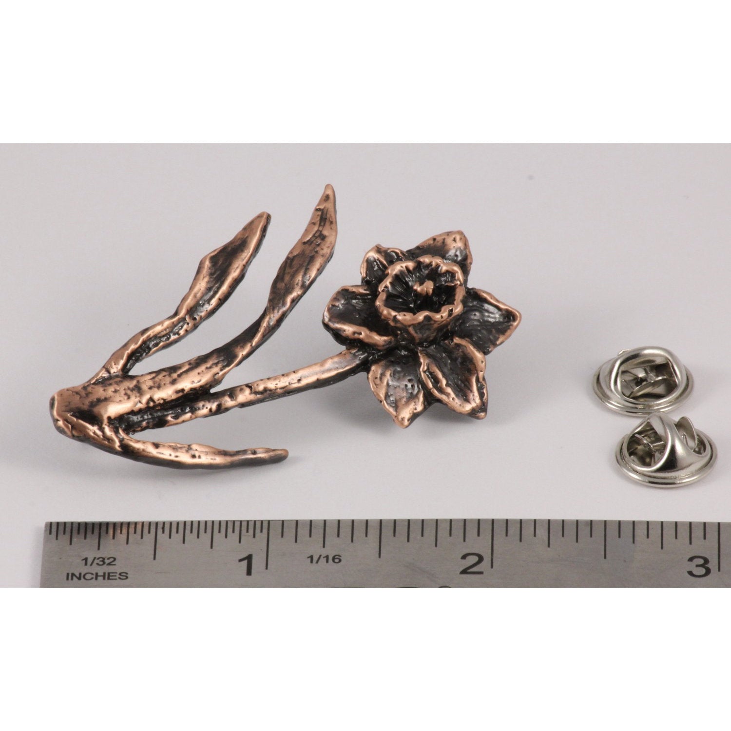 A handcrafted Daffodil Pin next to a ruler, available for sale at Creativeartisan.com - the image offers a sense of scale