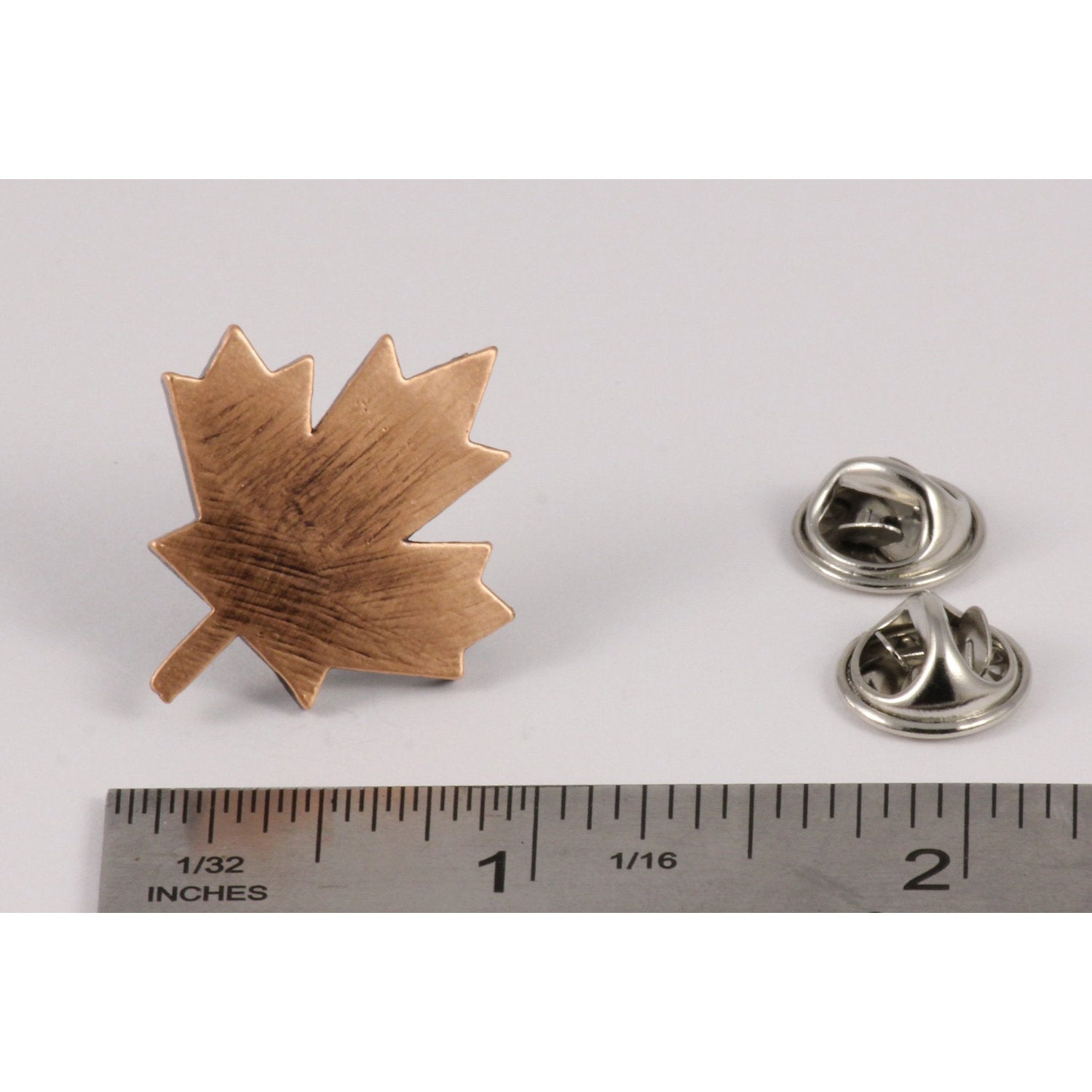A handcrafted Canadian Maple Leaf Pin next to a ruler, available for sale at Creativeartisan.com - the image offers a sense of scale