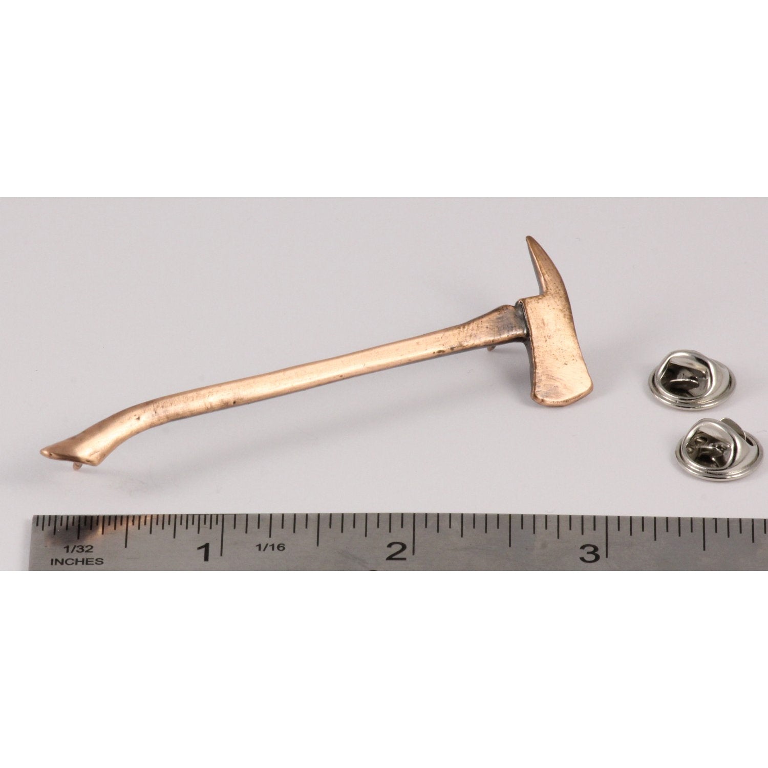 A handcrafted Firemans Axe Pin next to a ruler, available for sale at Creativeartisan.com - the image offers a sense of scale