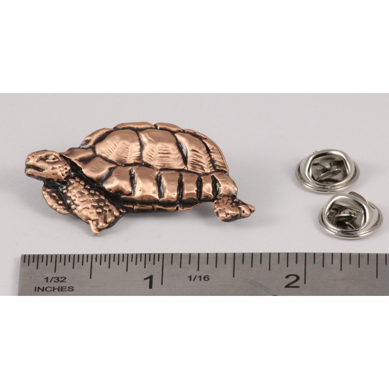 A handcrafted Tortoise Pin next to a ruler, available for sale at Creativeartisan.com - the image offers a sense of scale