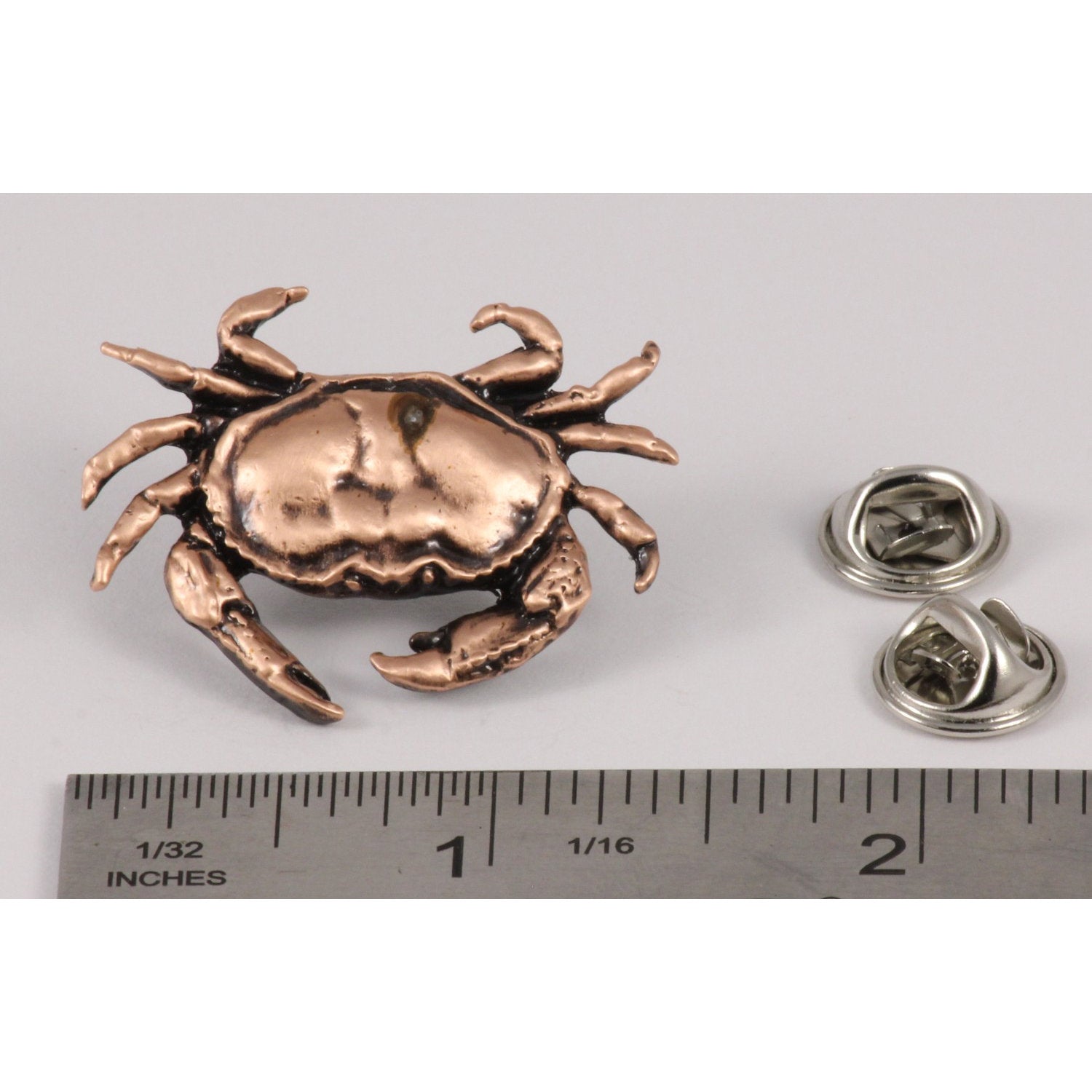 A handcrafted Dungeness Crab Pin next to a ruler, available for sale at Creativeartisan.com - the image offers a sense of scale