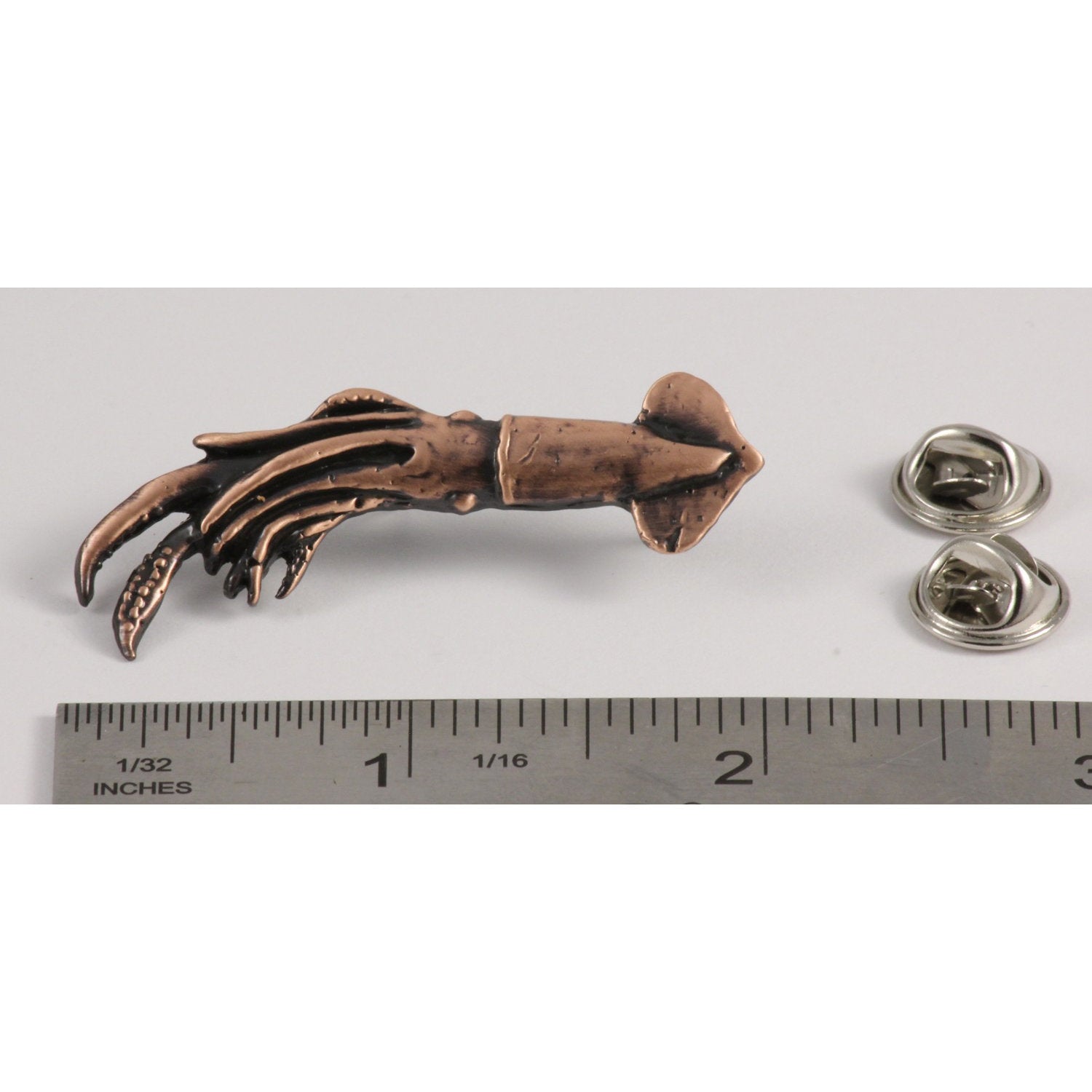 A handcrafted Squid Pin next to a ruler, available for sale at Creativeartisan.com - the image offers a sense of scale
