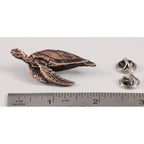 A handcrafted Sea Turtle Side View Pin next to a ruler, available for sale at Creativeartisan.com - the image offers a sense of scale
