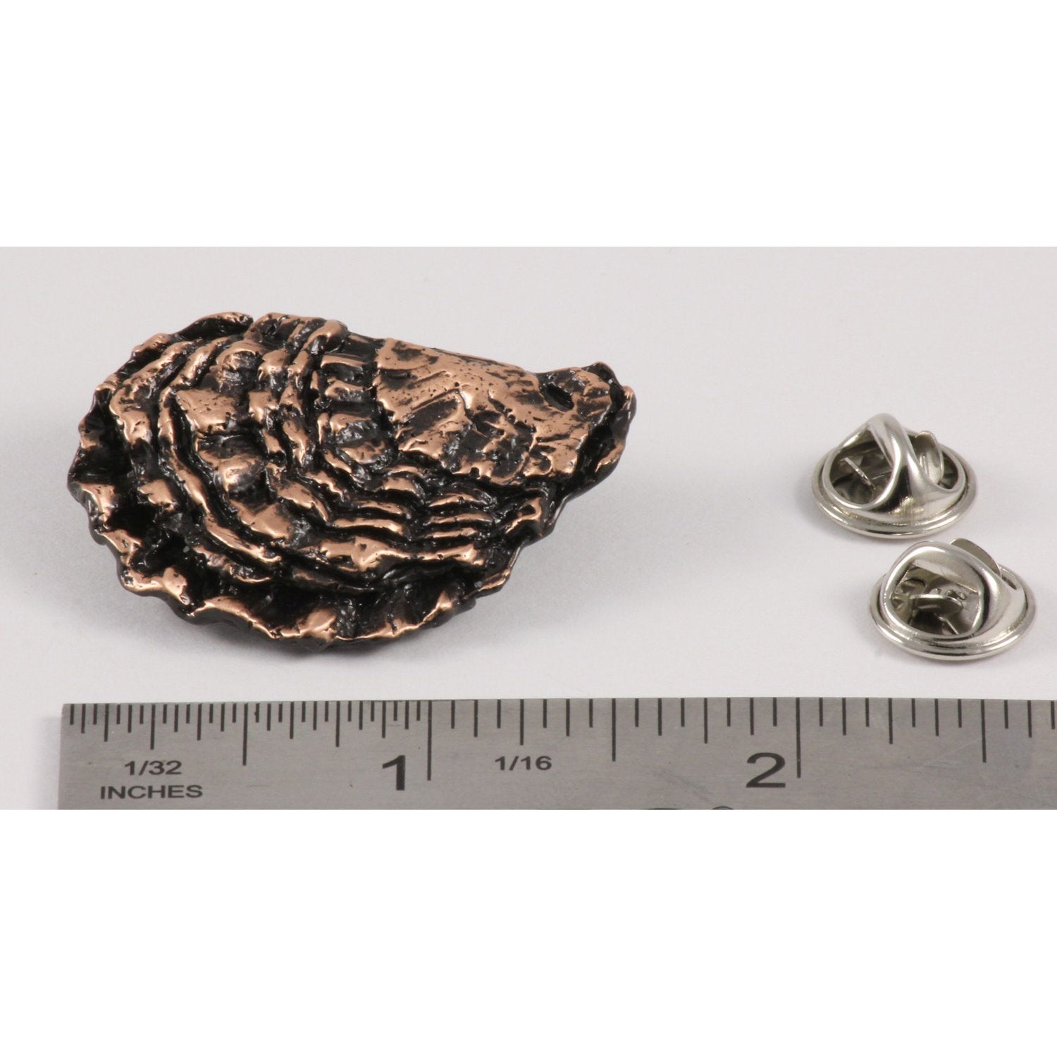 A handcrafted Oyster Shell Pin next to a ruler, available for sale at Creativeartisan.com - the image offers a sense of scale