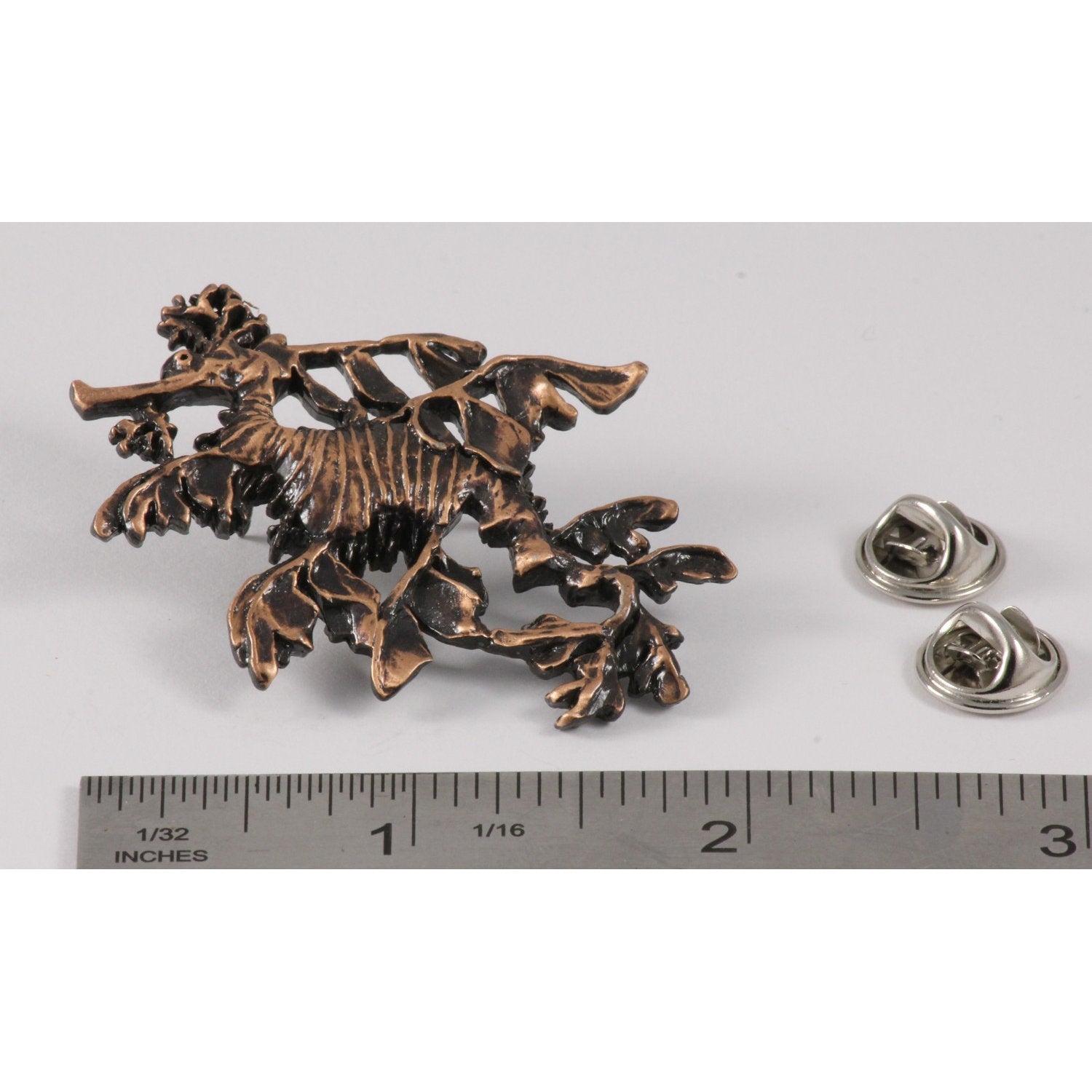 A handcrafted Sea Dragon Leafy Pin next to a ruler, available for sale at Creativeartisan.com - the image offers a sense of scale
