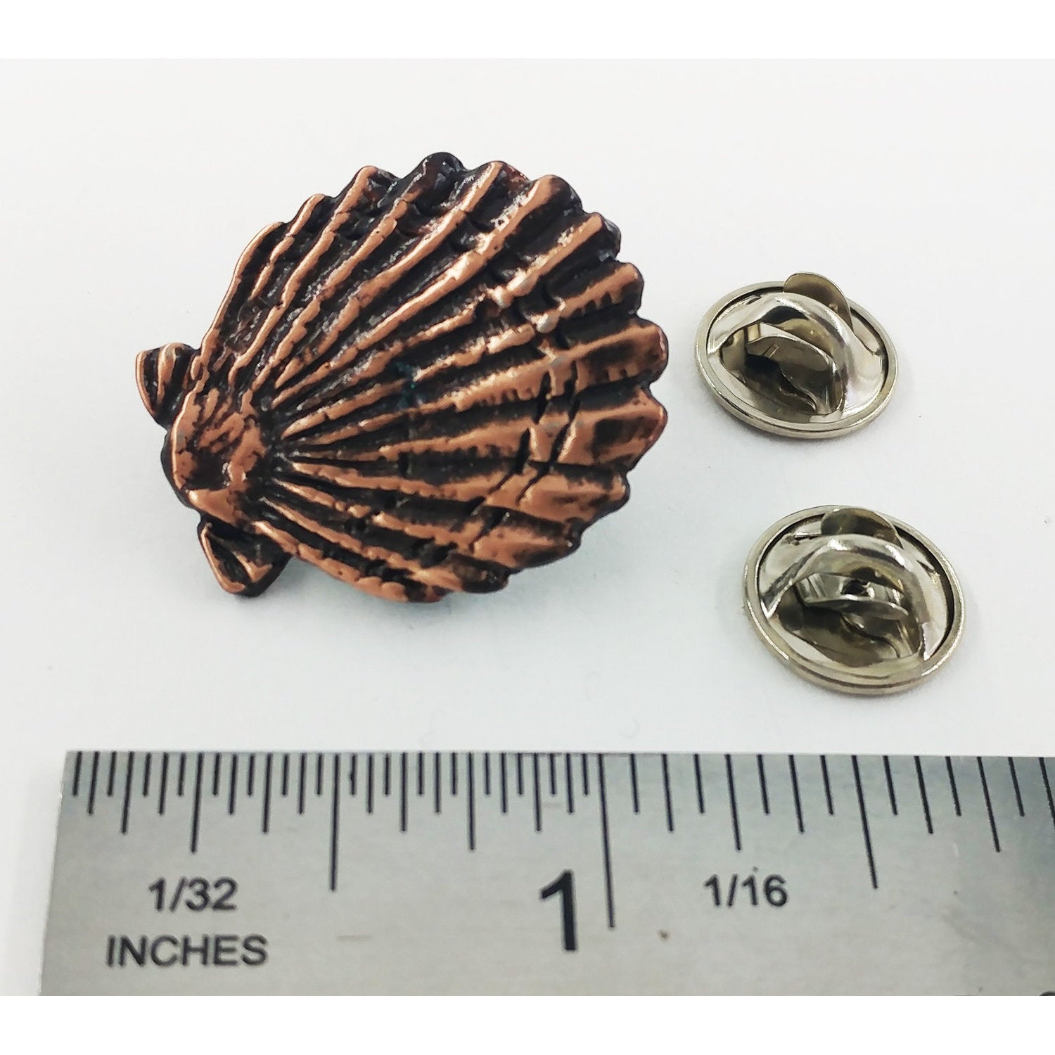 A handcrafted Scallop Shell Pin next to a ruler, available for sale at Creativeartisan.com - the image offers a sense of scale