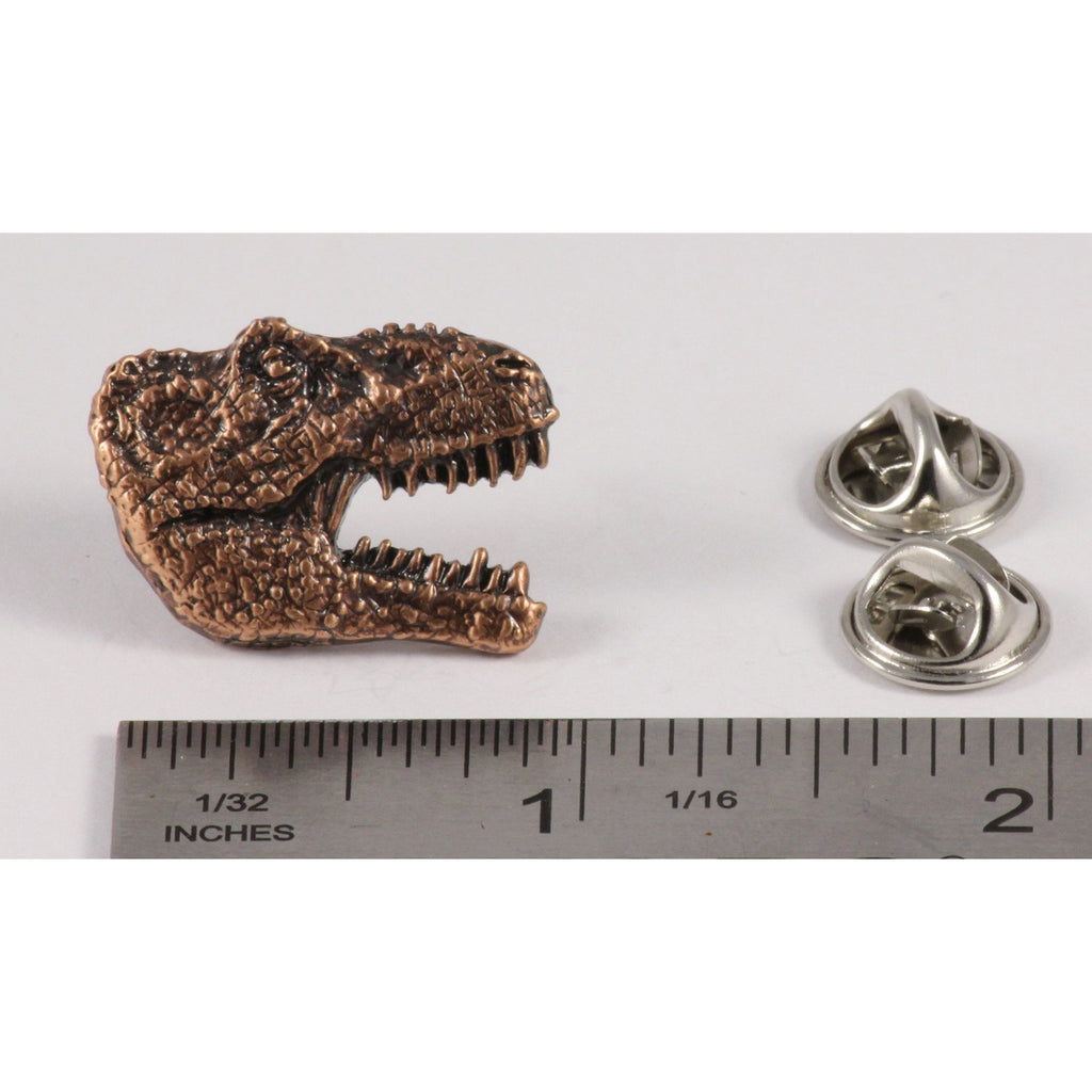A handcrafted Tyrannosaurus Rex Head Pin next to a ruler, available for sale at Creativeartisan.com - the image offers a sense of scale