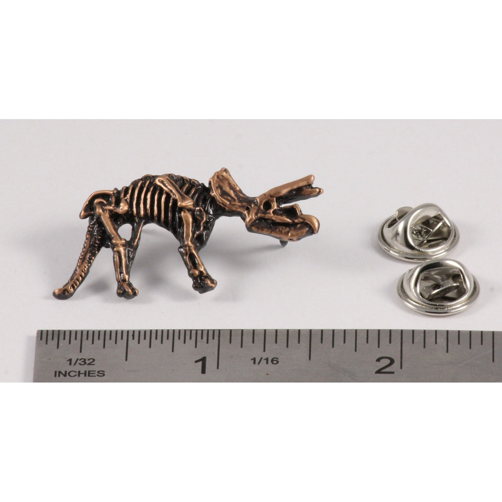 A handcrafted Triceratops Fossilized Full Body Pin next to a ruler, available for sale at Creativeartisan.com - the image offers a sense of scale