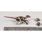 A handcrafted Velociraptor Pin next to a ruler, available for sale at Creativeartisan.com - the image offers a sense of scale