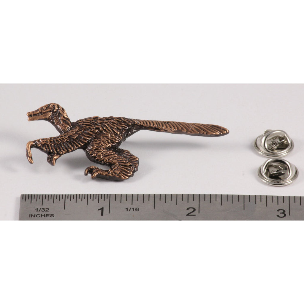 A handcrafted Feathered Velociraptor Pin next to a ruler, available for sale at Creativeartisan.com - the image offers a sense of scale