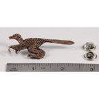 A handcrafted Feathered Velociraptor Pin next to a ruler, available for sale at Creativeartisan.com - the image offers a sense of scale